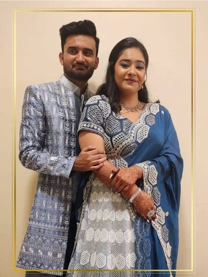 This couple is perfectly matched in their blue and silver outfits. Her lehenga features a unique geometric pattern, complemented by his stylish sherwani.