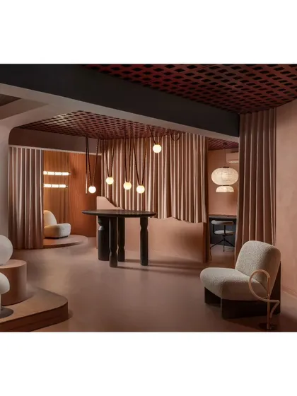 An overall view of the showroom's dynamic layout. The combination of open spaces and intimate nooks, all unified by the peach color scheme and grid ceiling, creates a cohesive yet varied retail experience.