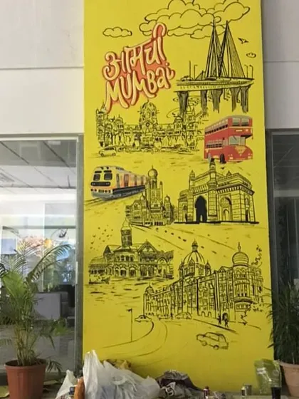The "Aamchi Mumbai" pillar mural during its installation, showing the scale of the piece within the office space.