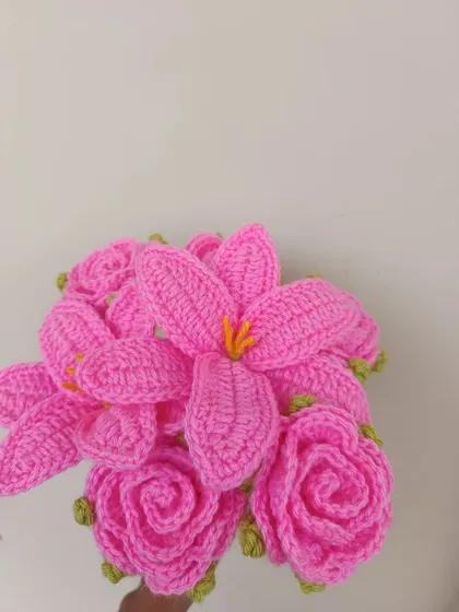 A close-up of a mixed bouquet with pink lilies and roses.