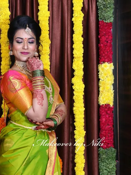 A complete look at Nirosha's engagement style. She wore a vibrant silk saree, and we created a soft glam look with a pretty pink lip and a chic updo.