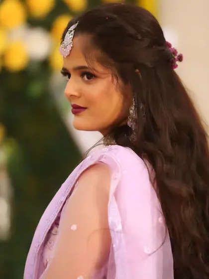 A side profile of the bride, showing the soft hairstyle with floral accents.