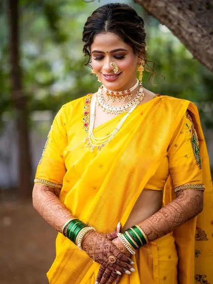 A professionally captured portrait of the bride in her monochrome yellow Navari look, highlighting the soft, glowing makeup.