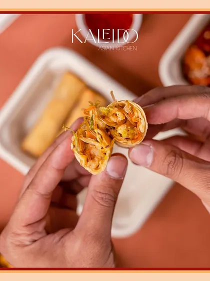 A look inside our crispy spring roll, held open to show the fresh and colorful vegetable filling. It's a perfect example of a classic appetizer done right.