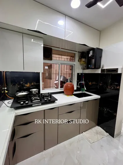 A practical and stylish L-shaped kitchen layout. The handleless drawers create a clean look, and the dual-tone cabinet colors add visual interest.