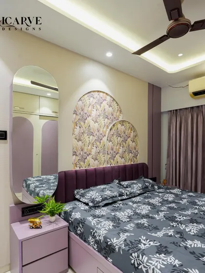 A bedroom design featuring a rich purple upholstered headboard and matching lavender wardrobes. The arched wallpaper panels and mirror create a cohesive and elegant look.