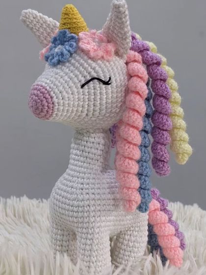 A full view of the pastel unicorn, standing proudly on a soft white surface.