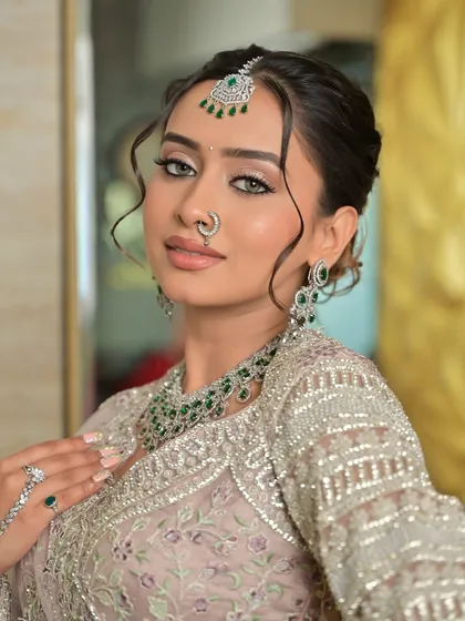 A confident and direct look from the bride, showcasing her striking eyes, flawless makeup, and the stunning rental jewellery.