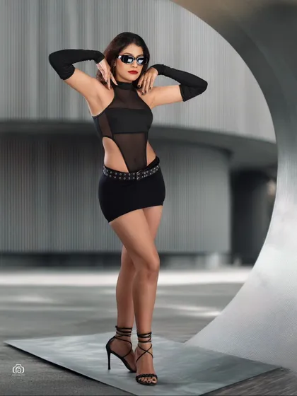 This image showcases a high-fashion concept with a futuristic feel. The model's pose and the metallic set design are enhanced by dramatic lighting, creating a visually striking editorial photograph.