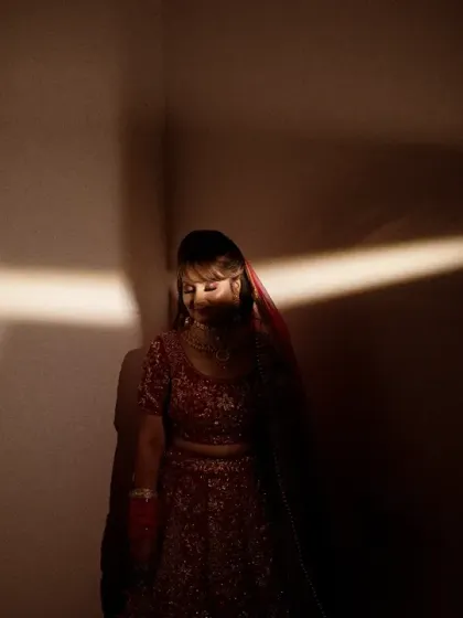 An artistic bridal portrait using dramatic shadows and a single sliver of light. This creates a moody, mysterious, and high-fashion look.