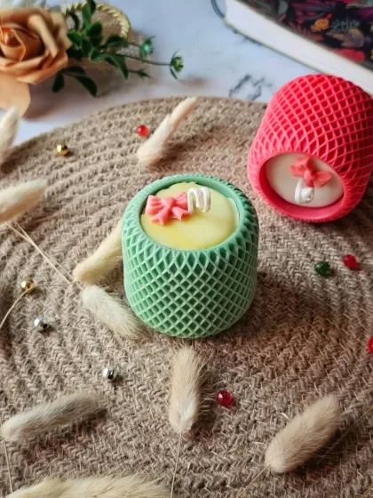 A pair of my Mesh Pattern Candles in green and pink. These are crafted to elevate your space, whether you're gifting them or keeping them as your own little luxury.