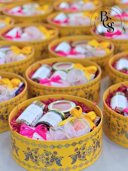 These beautiful yellow hat boxes are filled with curated goodies for a festive celebration. The intricate design on the box and the carefully chosen items inside make it a luxurious and memorable gift for any special occasion.