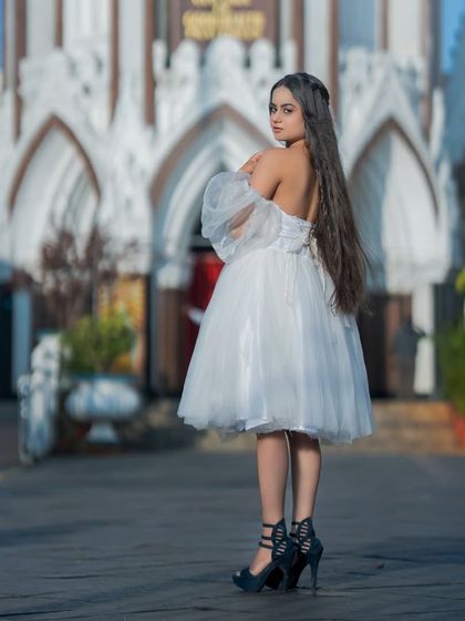 A back view showing the beautiful details of the white dress and the long, healthy hair.