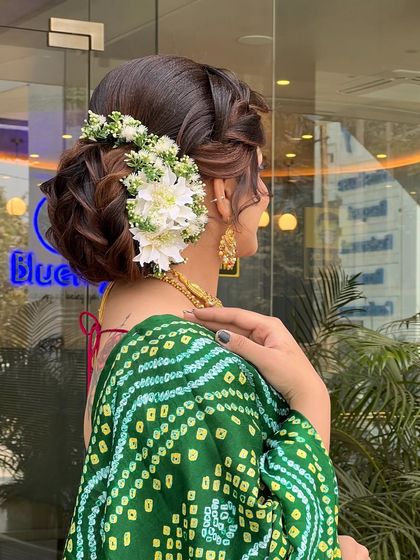 Another angle of the elegant floral updo, highlighting the smooth finish and the structure of the bun that ensures it holds perfectly throughout the event.