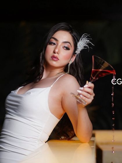 A glamorous, festive shot for Christmas, featuring a white dress and a glass of red wine. This is an example of themed holiday content.