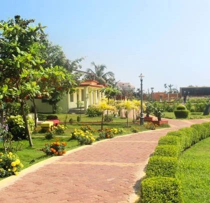 A beautifully landscaped park with winding brick pathways, neatly trimmed hedges, and colorful flower beds. This is an example of our public space design, focusing on creating enjoyable and accessible green areas.