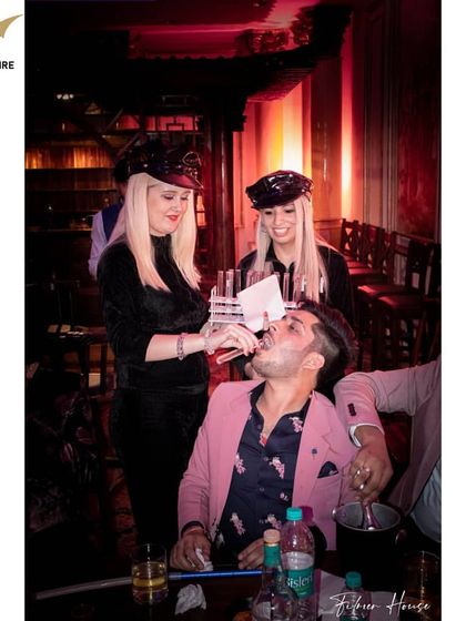 Our costumed servers add another layer of entertainment. Here, our shot girls serve drinks to guests, adding to the themed party experience.