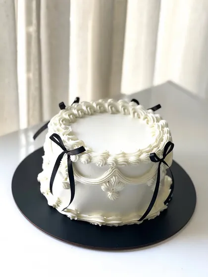 Vintage vibes and buttercream dreams. This is my take on the classic Lambeth cake trend, featuring intricate piping and elegant black ribbons.