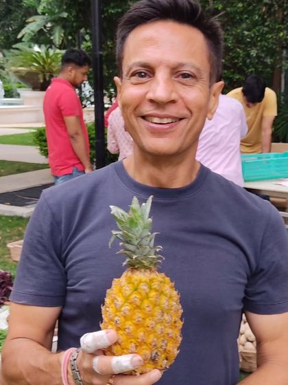 A customer proudly holding a mini pineapple, a unique find at the market.