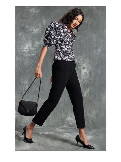 A classic look for a retail brand campaign. A black and white floral top with puff sleeves is paired with tailored black trousers for a timelessly chic office-to-evening outfit.