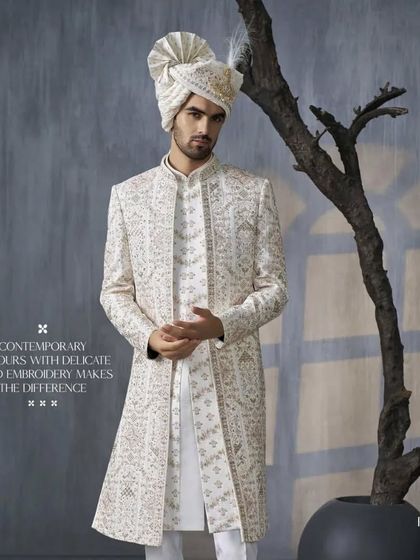 This full-length view showcases a contemporary sherwani with delicate hand embroidery. The clean lines and modern colors are designed for the groom who appreciates understated luxury.