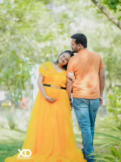 A candid and romantic walking shot of a couple in a lush green park.