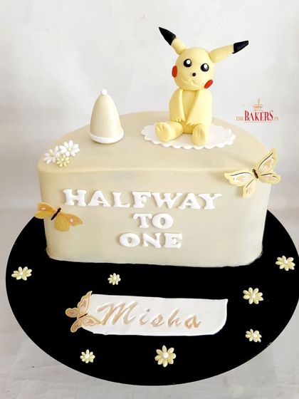 A cute Pikachu-themed cake to celebrate being "Halfway to One!" This half-cake design is perfect for a six-month celebration, and the adorable Pikachu topper makes it extra special for Misha.