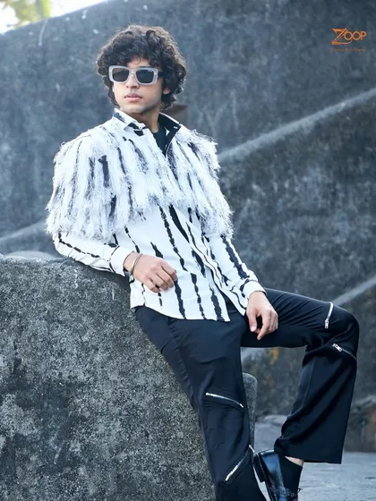 A different angle of our edgy black and white shirt with feathered details, a breathable piece that is the epitome of summer sophistication.