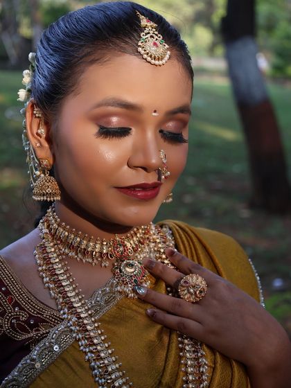 A close-up portrait in the yellow half-saree. You can see the details of the layered necklaces, nose ring, and maang tikka that are included in the rental.