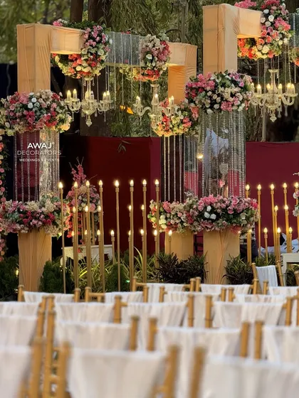A detail of the walkway decor, with hanging floral arrangements, crystal chandeliers, and candle-lit stands.