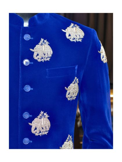 A close-up of our royal blue velvet bandhgala. The silver threadwork of the elephant motifs is incredibly detailed, showcasing the fine craftsmanship that goes into each garment.