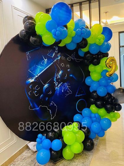 The balloon garland for this gaming party includes a gold foil number '9' to personalize the decoration for the birthday boy.