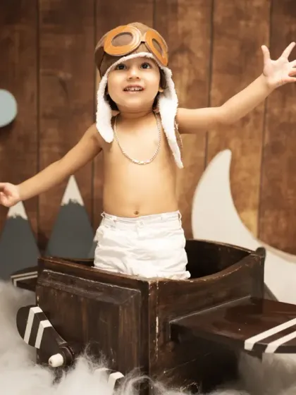 "Ready for takeoff." This two-year-old enjoys our aviator-themed setup, complete with a wooden airplane, clouds, and a pilot hat.