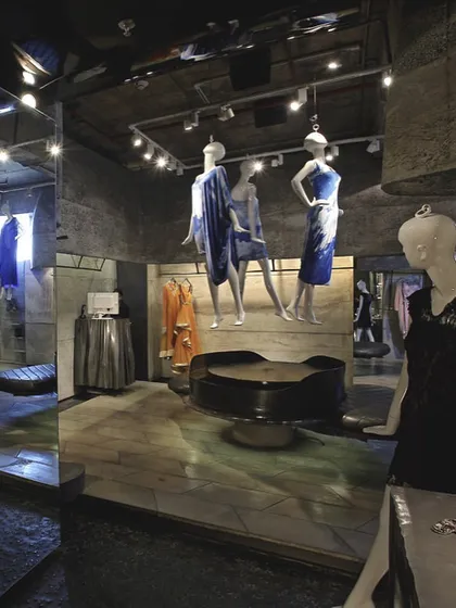The interior of the Gaurav Gupta couture store in New Delhi was conceived as a sculpted cavern. Raw concrete walls and strategically placed mirrors create a dramatic, gallery-like environment where the fashion pieces are displayed as artifacts.