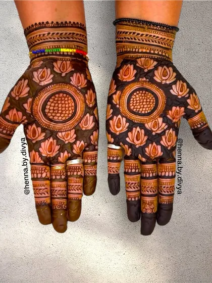 I love playing with modern techniques like this cutwork or negative space design. The bold lotus patterns are filled in, making the surrounding skin appear as part of the art, creating a striking and contemporary look.