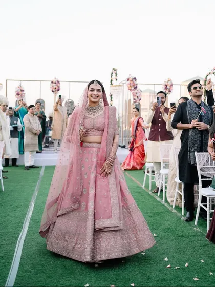 The bride's radiant smile as she walks down the aisle, with all eyes on her. A moment of pure grace and happiness.