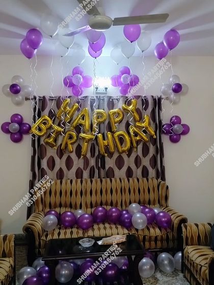 A purple and silver themed birthday decoration in a living room.