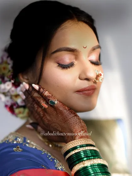 A close-up on the makeup details. The soft pink eyeshadow, defined lashes, and perfectly shaped bindi create a look of pure elegance.