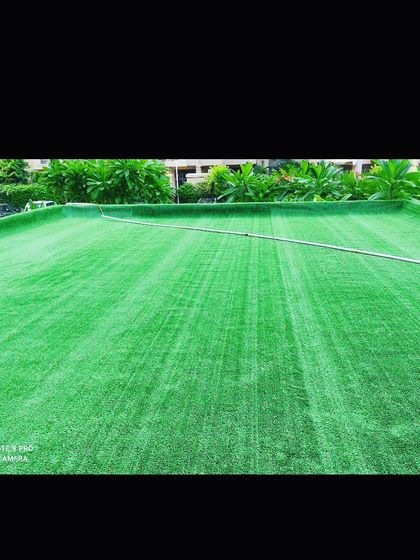 A large expanse of freshly installed artificial turf. The lines from the roller show how it is laid, and these will disappear as the blades settle.