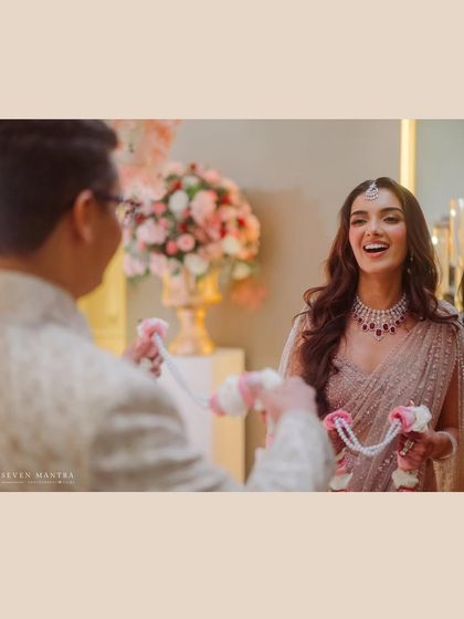 A candid moment during the garland exchange, filled with laughter and happiness.