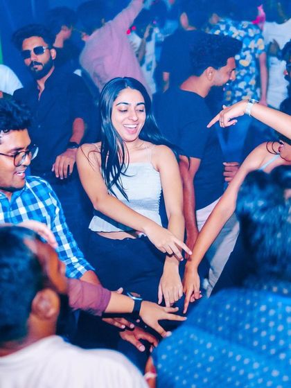 A group of friends dancing in a circle, creating their own party within the party.