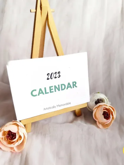 A clean shot of the 2023 calendar cover on its easel, waiting to be personalized with your photos.