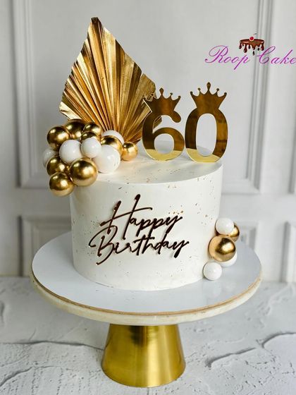 Turning 60 never looked so golden. A luxe celebration cake fit for royalty, featuring a golden palm leaf, elegant spheres, and crown toppers.