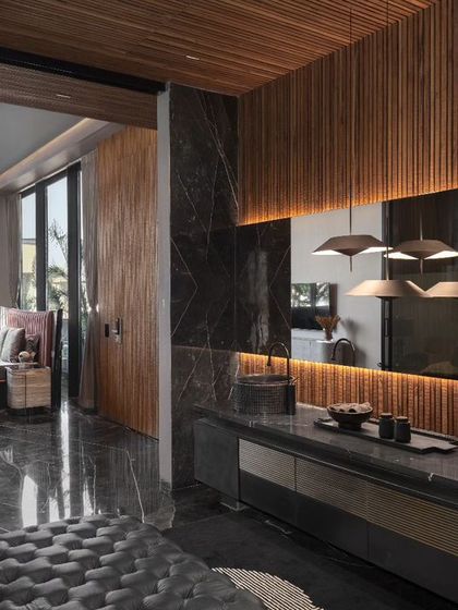 This design showcases a seamless integration between a bedroom and a luxurious restroom, connected by a sleek glass door. This open concept maximizes space and light while maintaining privacy, adding a touch of modern sophistication to the home.