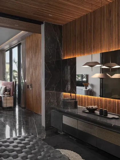This design showcases a seamless integration between a bedroom and a luxurious restroom, connected by a sleek glass door. This open concept maximizes space and light while maintaining privacy, adding a touch of modern sophistication to the home.