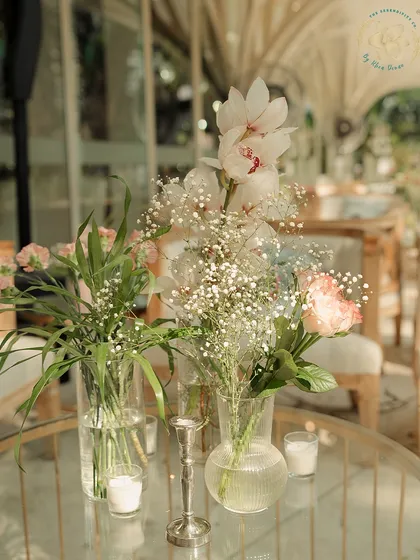 A close-up of a delicate floral centerpiece, with baby's breath and orchids. It's the small, beautiful details that complete the picture.