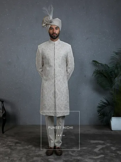A frontal view of the Mughal-inspired ivory sherwani. The clean lines and structured fit provide a regal posture, while the intricate embroidery offers a visual narrative of our rich heritage.