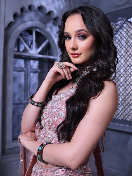 A powerful and chic pose. The open hairstyle and the glamorous makeup create a look that is perfect for the modern, confident woman.