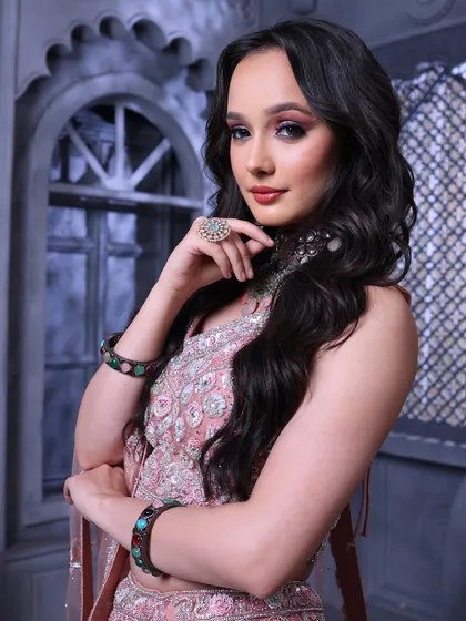 A powerful and chic pose. The open hairstyle and the glamorous makeup create a look that is perfect for the modern, confident woman.