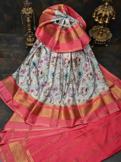 This light blue floral printed silk saree with a bright pink and gold border is a modern classic. It combines the grace of silk with the charm of floral prints.
